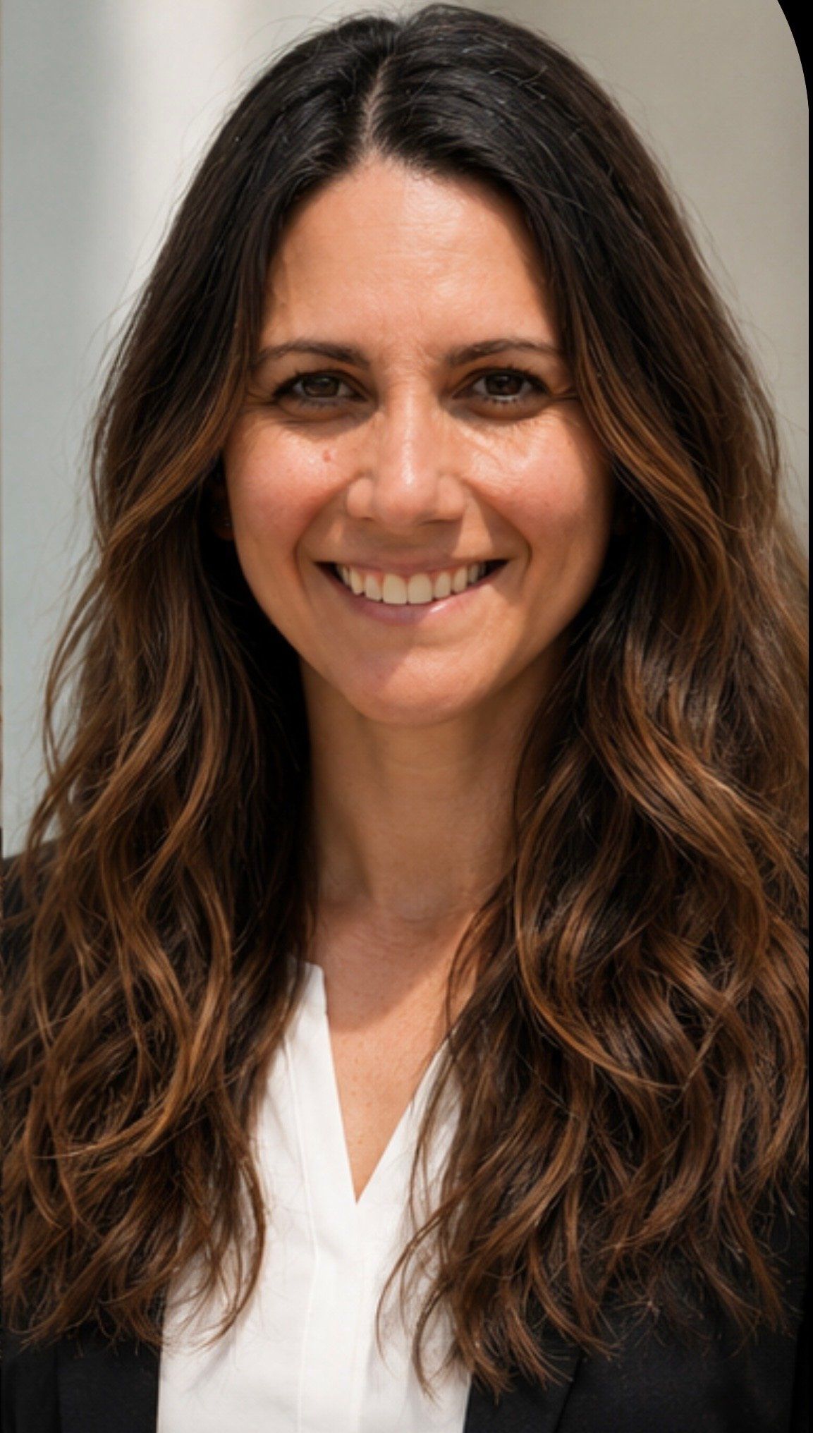 Portrait of Alyssa LaPlaga, smiling, in a white top and dark blazer.